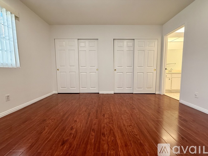 A room with wooden floors and two white doors.