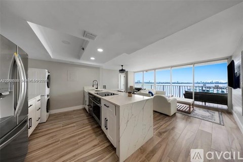 A modern kitchen with wooden floors and a large island.