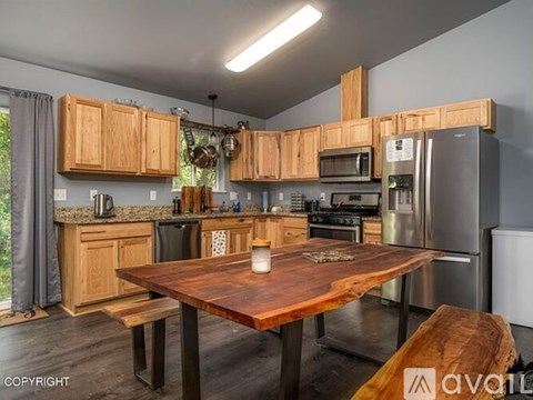 A kitchen with wooden cabinets and a wooden table with a candle on it.