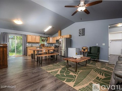 A living room with a wooden floor and a ceiling fan.