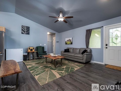 A living room with a grey couch and a wooden table.