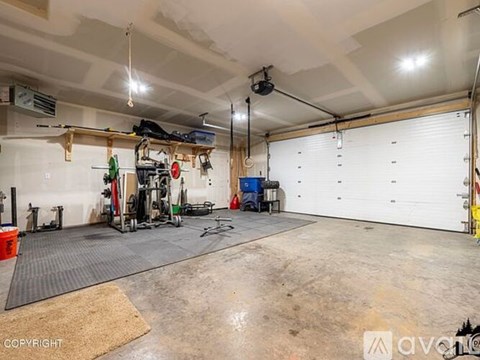A garage with a gym setup and a white wall.