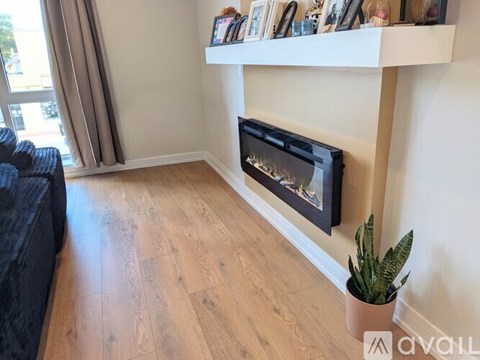 A modern living room with a fireplace and a potted plant.