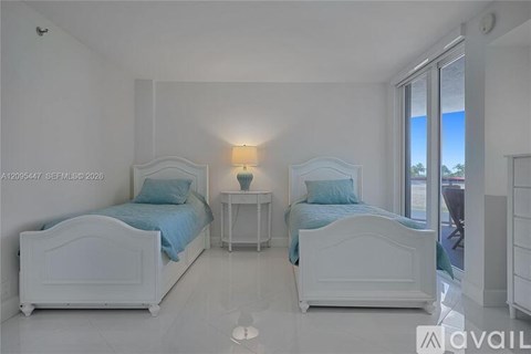 A bedroom with two beds and a nightstand.