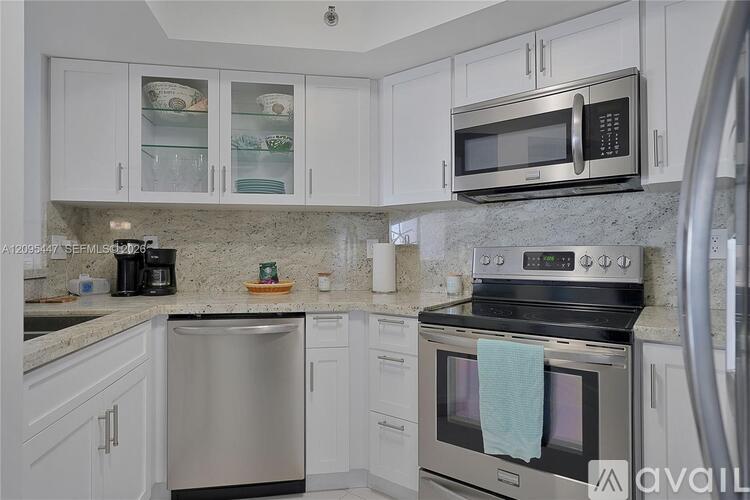 A kitchen with white cabinets and a stainless steel dishwasher.