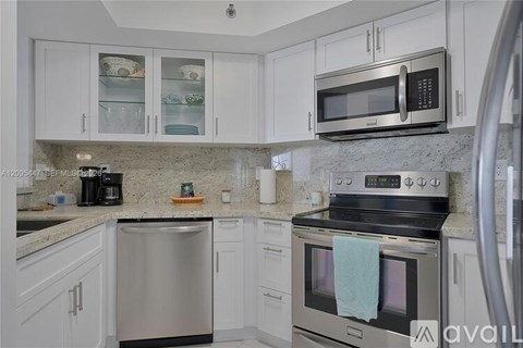 A kitchen with white cabinets and a stainless steel dishwasher.