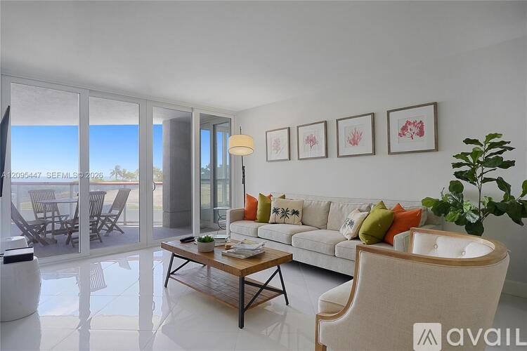 A living room with a white couch, a wooden coffee table, and a large window with a view of the outdoors.