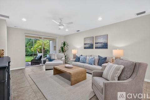 A living room with a grey sofa, a wooden coffee table, and a ceiling fan.