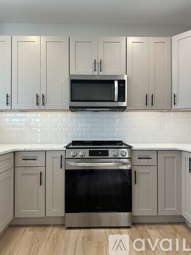 A kitchen with a stove top oven and microwave above it.