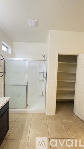 A kitchen with a refrigerator and an open pantry door.