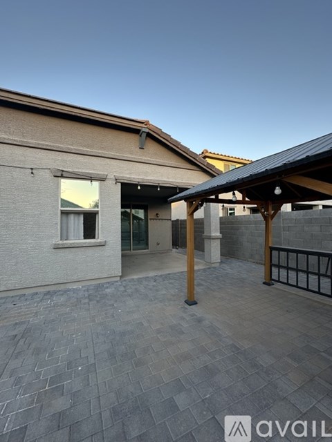A patio area with a roof and a building in the background.