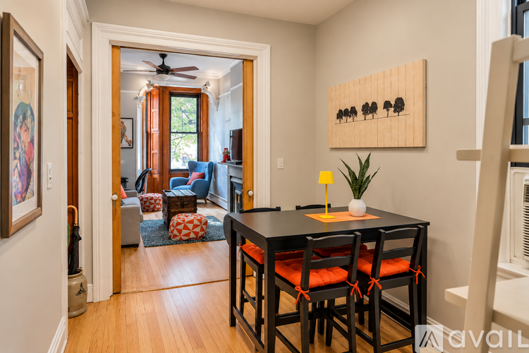 A dining room with a table and chairs.