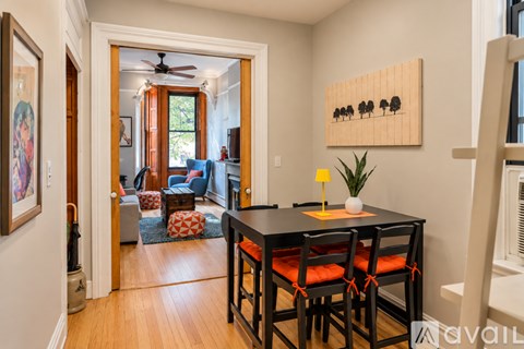 A dining room with a table and chairs.