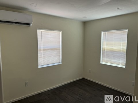 A room with a window and a wall-mounted air conditioner.