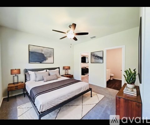 A bedroom with a large bed and a ceiling fan.