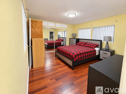 A bedroom with a bed, nightstand, and wardrobe.