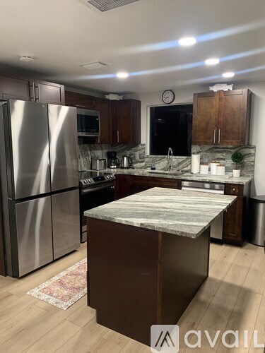 A kitchen with a marble countertop and stainless steel appliances.