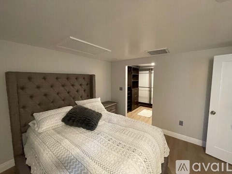 A bedroom with a large bed and a tufted headboard.