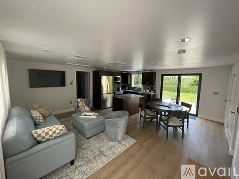 A living room with a grey couch and a television on the wall.