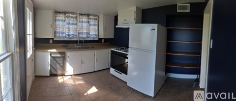 A kitchen with a white fridge and cabinets.