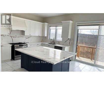 A kitchen with a marble countertop and white cabinets.
