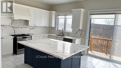 A kitchen with a marble countertop and white cabinets.