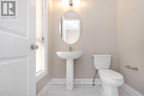 A white toilet sits next to a sink in a small bathroom.
