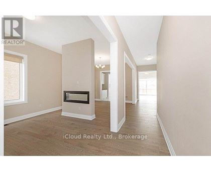 A spacious room with a fireplace and wooden flooring.
