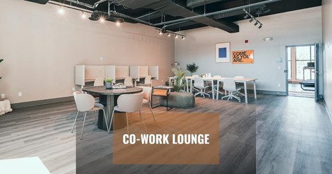 A co-work lounge with white chairs and tables.