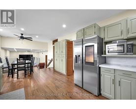 A kitchen with a refrigerator that has a digital display showing the time.