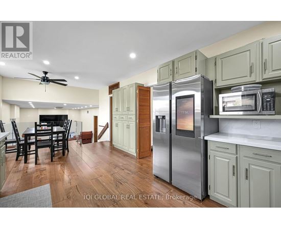 A kitchen with a refrigerator that has a digital display showing the time.