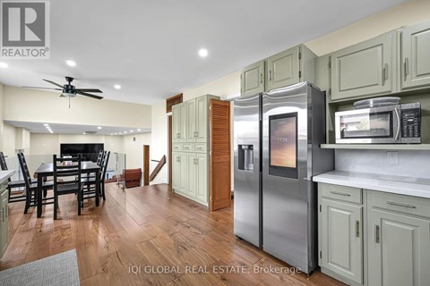 A kitchen with a refrigerator that has a digital display showing the time.