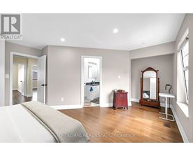 A bedroom with a large bed and a vanity with a mirror.
