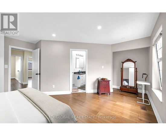 A bedroom with a large bed and a vanity with a mirror.