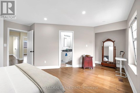 A bedroom with a large bed and a vanity with a mirror.