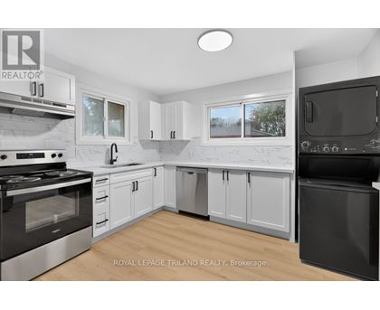 A modern kitchen with white cabinets and black appliances.
