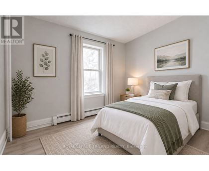 A bedroom with a large bed and a window with curtains.