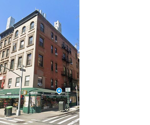 A street view of a city with a building on the left and a store on the right.