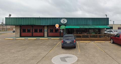 A parking lot with a green building and a sign that says "FREE PARKING".