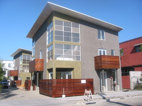 A modern building with a red and brown fence in front.