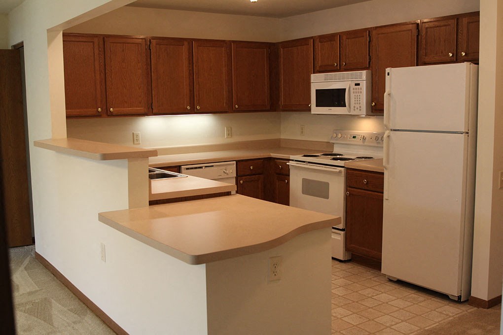 a kitchen with white appliances and wooden cabinets