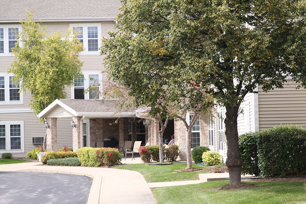 a house with a driveway and trees in front of it