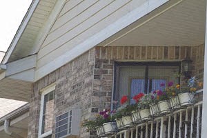 a balcony with flowers on a brick house