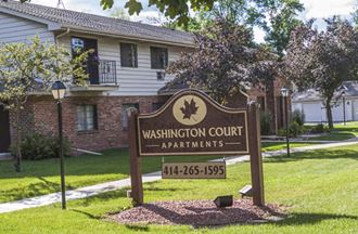 a sign court apartments in front of a house