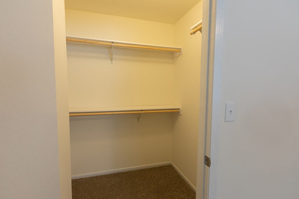 an empty closet in a bedroom with a white door
