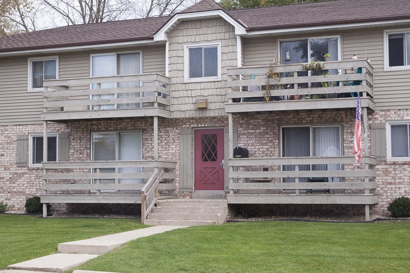 the front of a house with two balconies and a red door