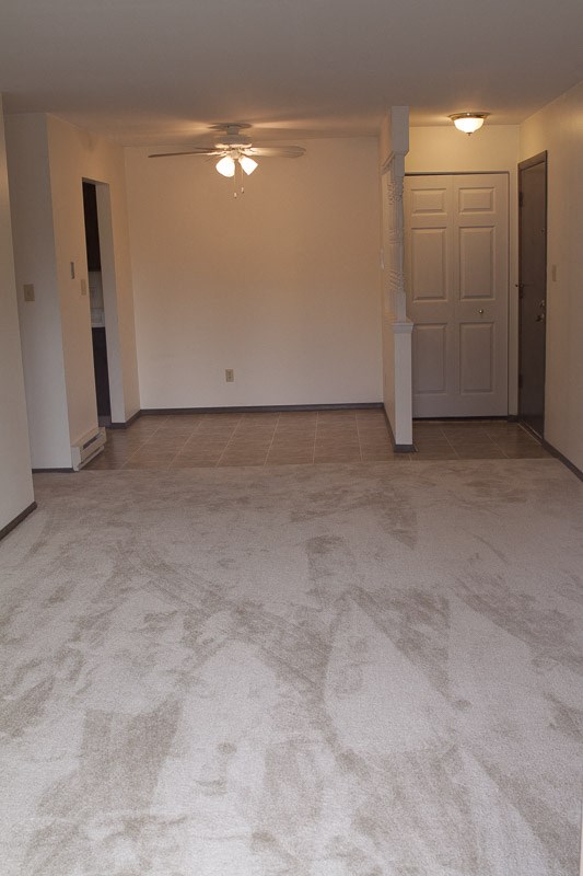 an empty living room with marble flooring and a white door