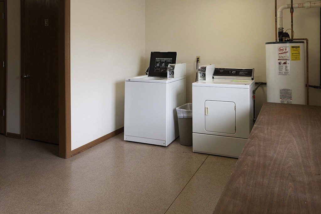 two washers and two refrigerators in a room