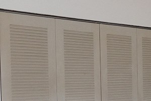 a room with white walls and carpet and two closet doors