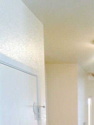 A long hallway with white walls and wood floors.